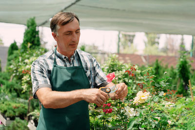 Portrait of young man holding plant