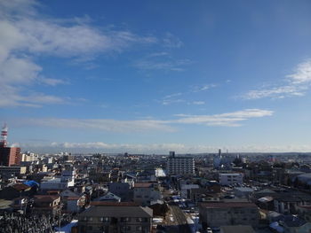 Aerial view of buildings in city against sky