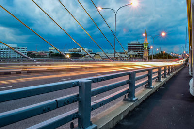 Light trails on road against sky at dusk