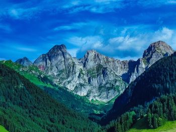 Panoramic view of mountains against blue sky