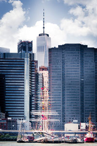 Skyscrapers in city against cloudy sky