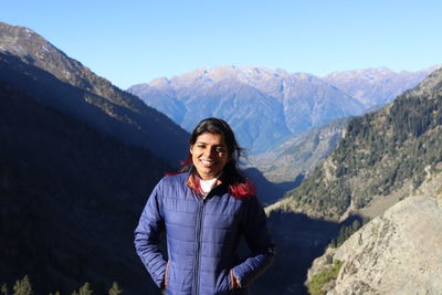 Portrait of young man standing against mountain