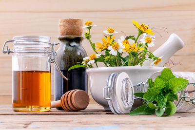 Close-up of flowers with food and drinks on table