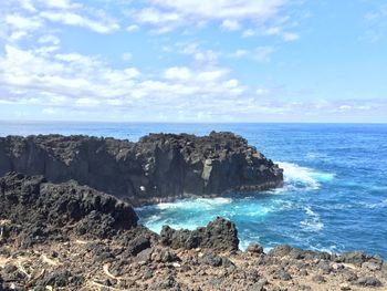 Scenic view of rocks on beach against sky