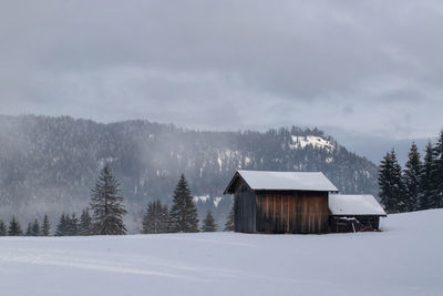 Built structure on snow covered landscape against sky