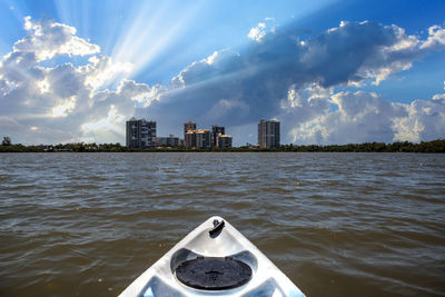 Sea by buildings against sky