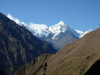 Scenic view of mountains against blue sky