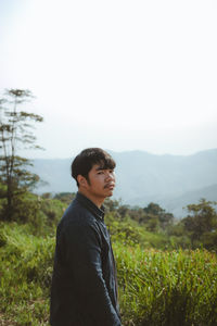 Side view of young man standing on land