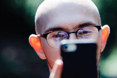 Close-up portrait of young man using mobile phone