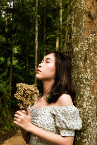 Side view of young woman in forest