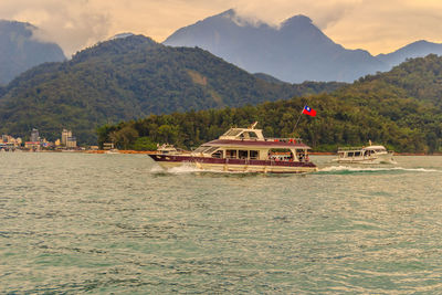 Boat in river with mountain range in background