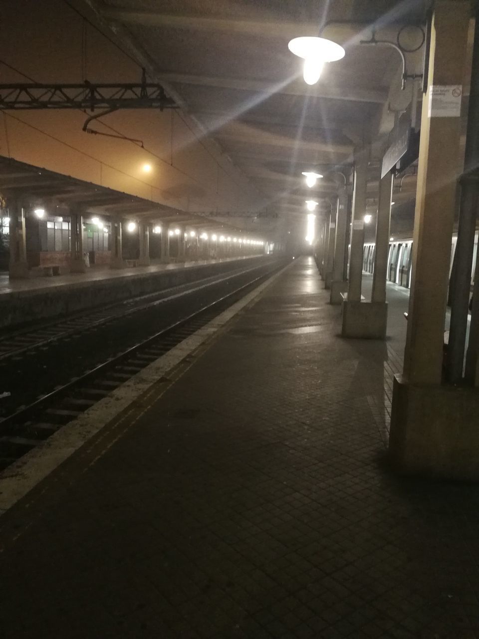 EMPTY ILLUMINATED RAILROAD STATION PLATFORM