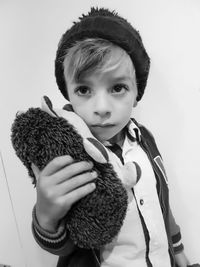 Portrait of boy holding camera over white background