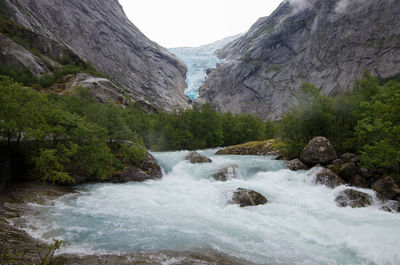 Scenic view of waterfall against sky