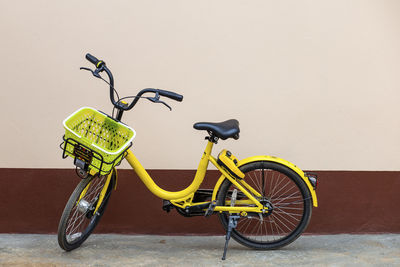 A yellow bicycle parked next to the house leave space for the text.