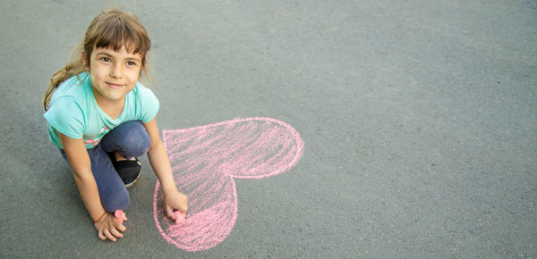 High angle view of girl drawing on road