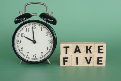 Close-up of alarm clock against blue background
