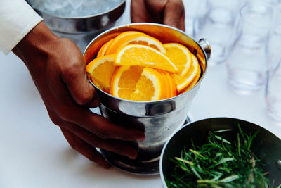 Close-up of hand holding drink on table