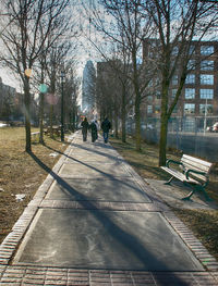 Rear view of people walking on footpath in park