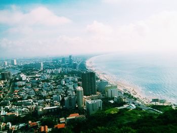 Aerial view of cityscape by sea against sky