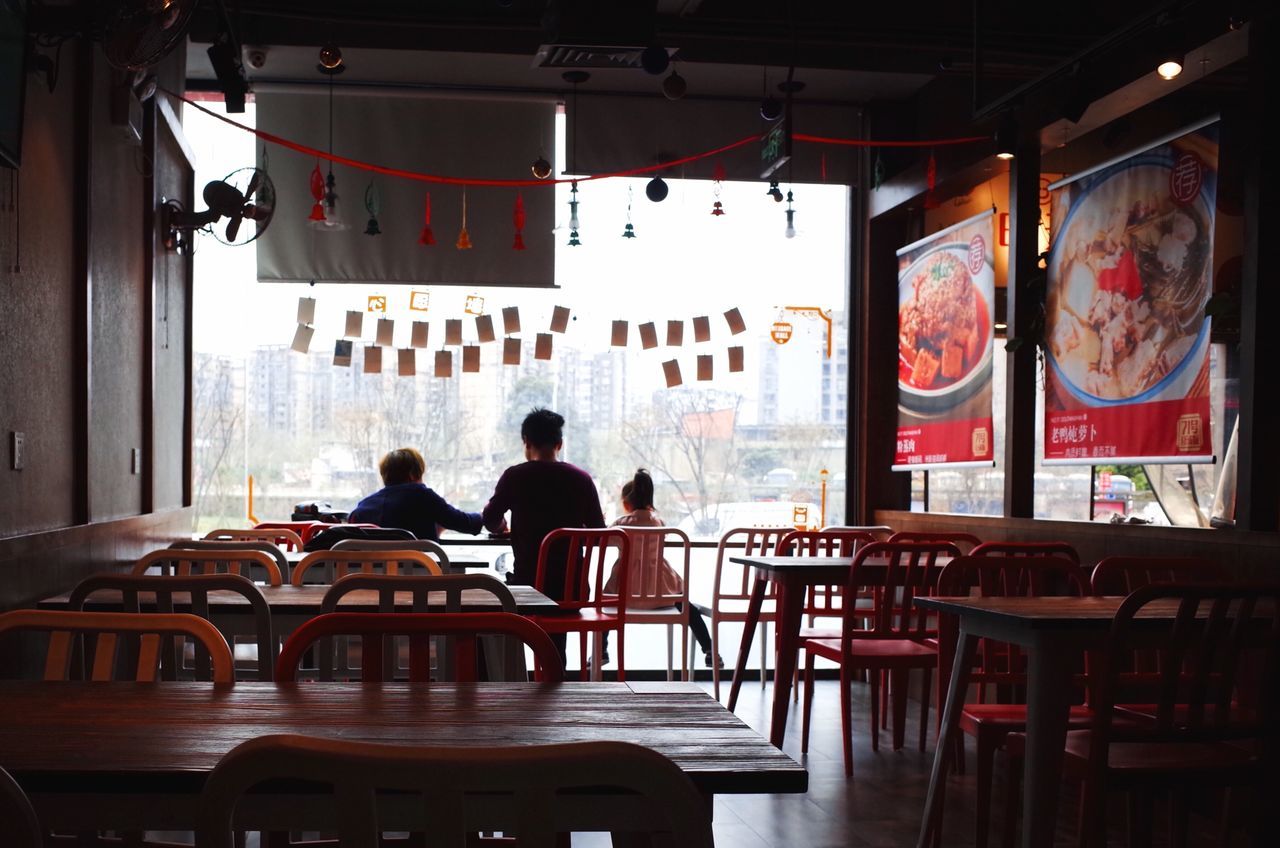 table, real people, seat, chair, group of people, men, indoors, restaurant, lifestyles, architecture, people, cafe, women, rear view, sitting, business, adult, day, leisure activity, lighting equipment