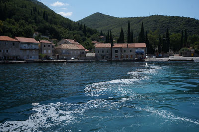 Houses by sea against sky