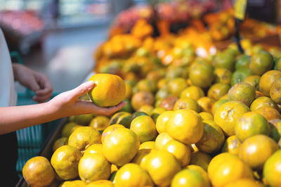 Close-up of hand holding fruits for sale at market stall