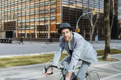 Young man riding bicycle on city street