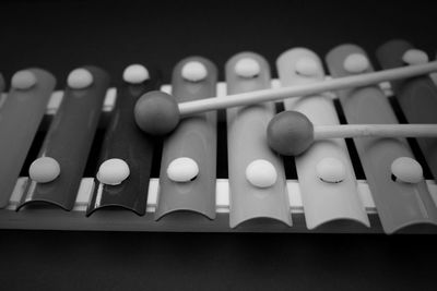 Close-up of mallets with xylophone against black background