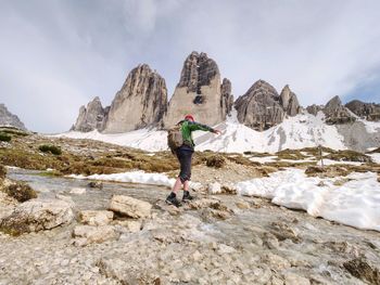 Man crossing river. spring panorama view from popular trail  tre cime di lavaredo, italien alps