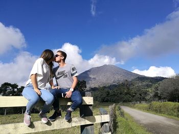 Friends standing on mountain against sky