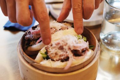 Close-up of hand holding ice cream on table