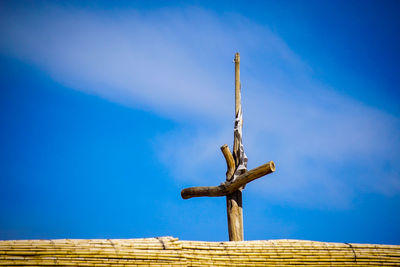 Low angle view of a cross against blue sky