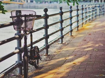 Bicycle parked on footpath by railing