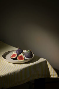 Figs fruits placed on a small plate on a table with a tablecloth and sunshine