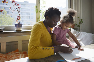 Mother and daughter drawing together