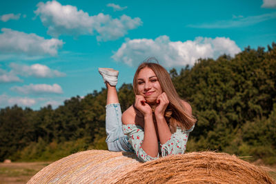 Portrait of young woman sitting on field