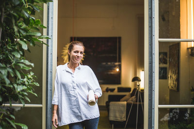 Portrait of female design professional standing at house entrance