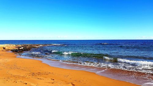 Scenic view of sea against clear blue sky