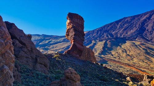 Scenic view of mountains against clear blue sky