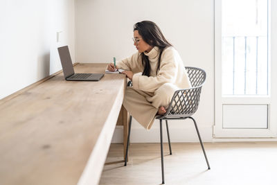 Young freelancer with laptop working at home office