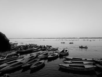 Boats moored in sea against clear sky