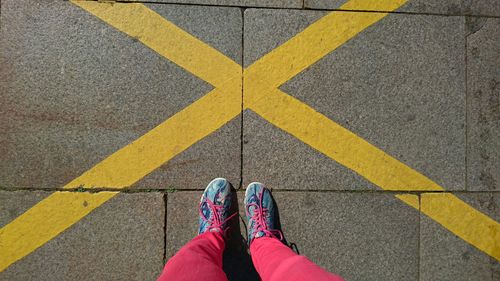 Low section of woman standing on footpath