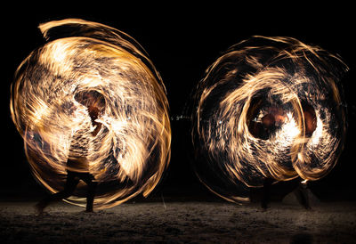 Man spinning wire wool at night