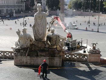 Rear view of man and woman standing by sculpture