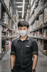 Portrait of young man standing outdoors with face mask