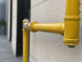 Close-up of yellow pipe on metal pole