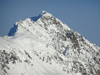 Scenic view of snowcapped mountains against clear blue sky