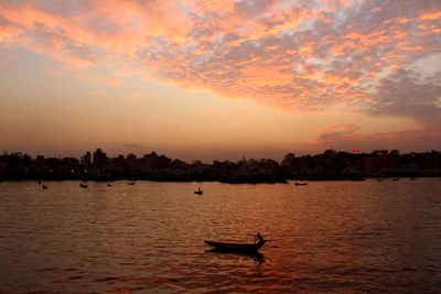 Silhouette boat in sea against sky during sunset