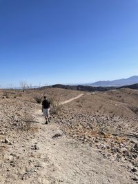 Rear view of man on land against clear sky